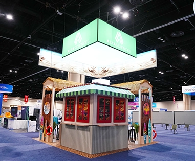 Altasciences green hanging sign structure suspended over a tropical rental booth
